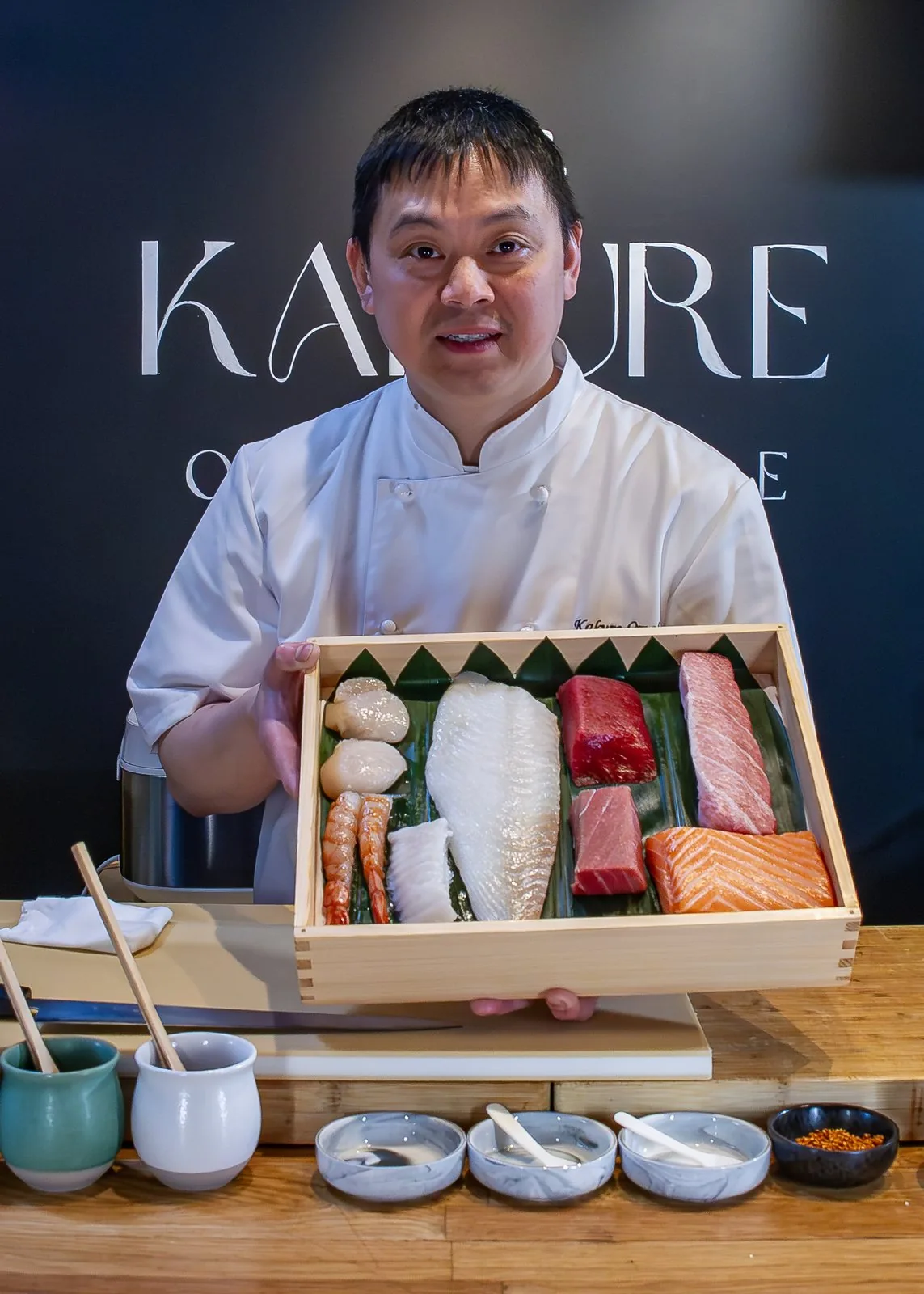 Chef Akira med en kasse fersk sushifisk foran Kakure-veggen