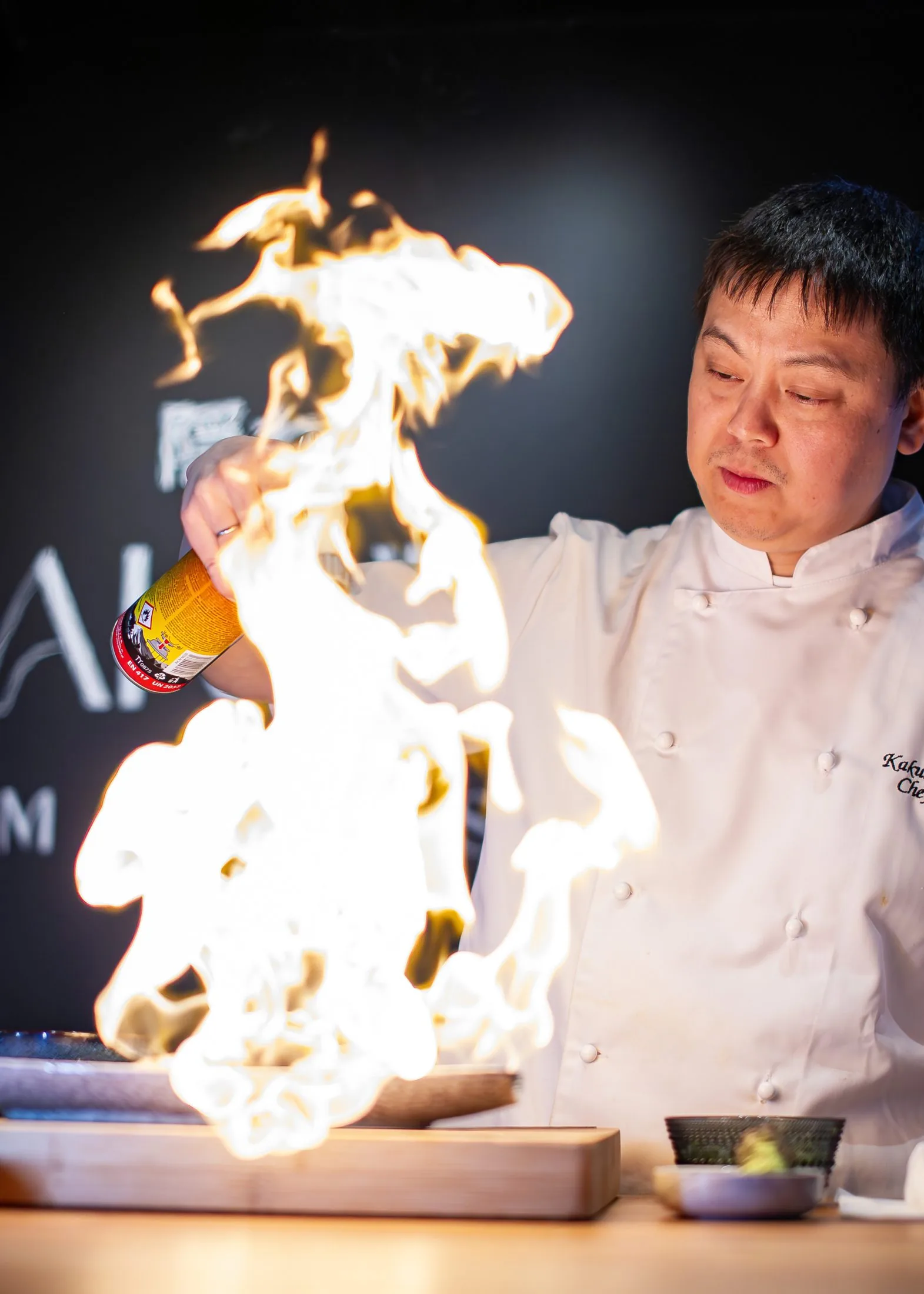 Chef Akira flamberer en rett ved disken hos Kakure Omakase